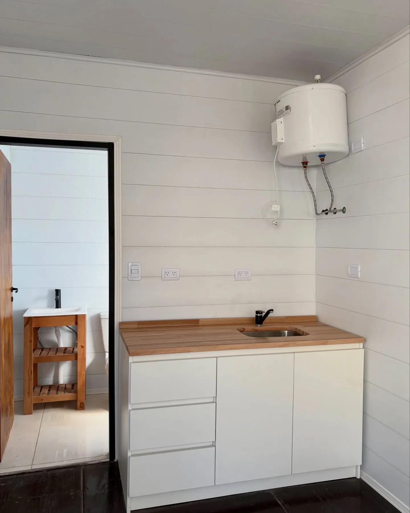 Kitchenette con mesada de madera dentro de un contenedor